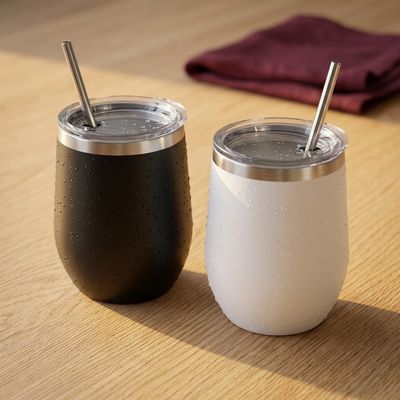 Dos vasos cuneros térmicos, uno negro y otro blanco, con tapa